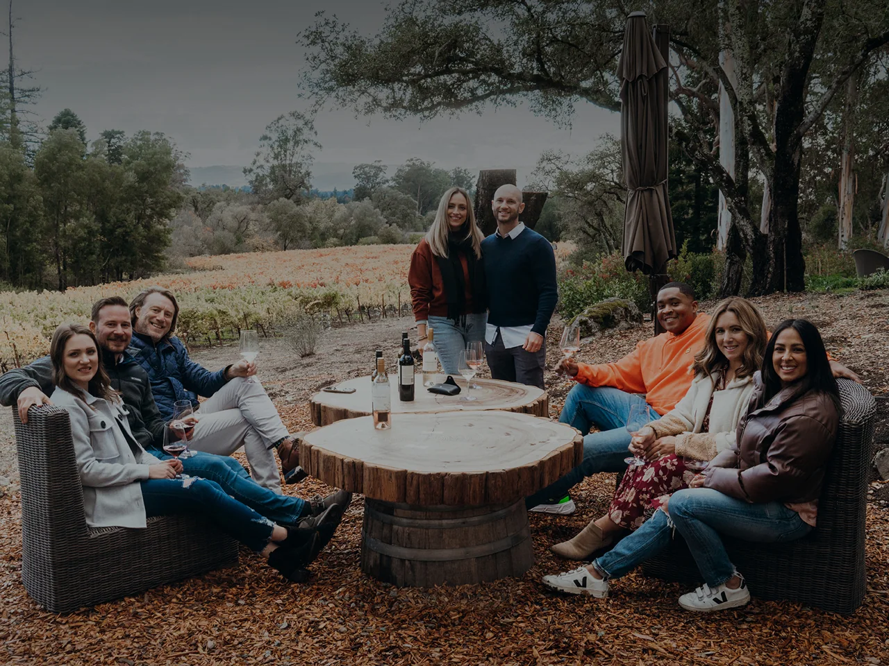 The team gathered outdoors overlooking a vineyard.