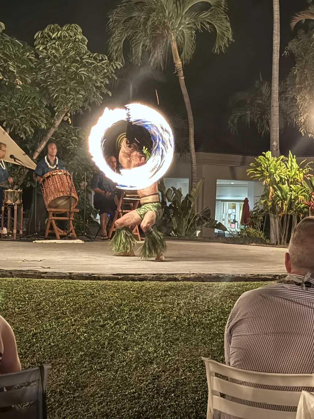 A performer spinning fire on an outdoor stage.
